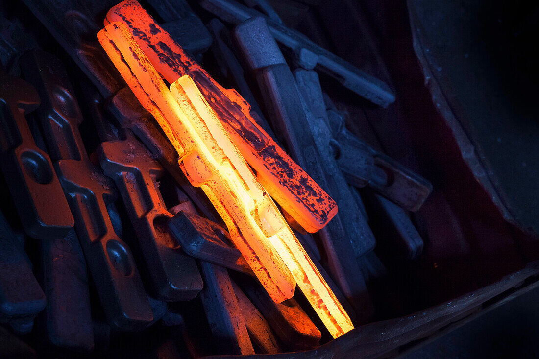 Red hot newly forged straps (mining components) cooling down