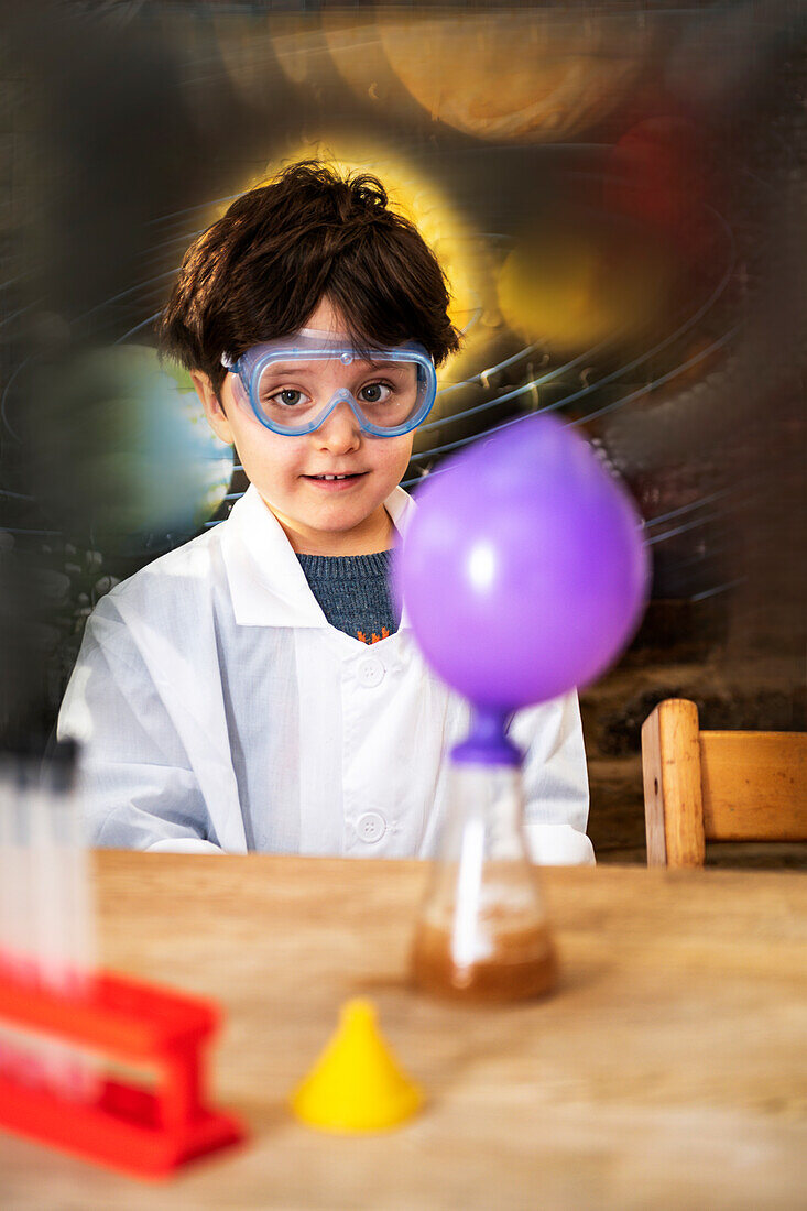 UK, Porträt eines lächelnden Jungen (4-5), der zu Hause naturwissenschaftliche Experimente durchführt