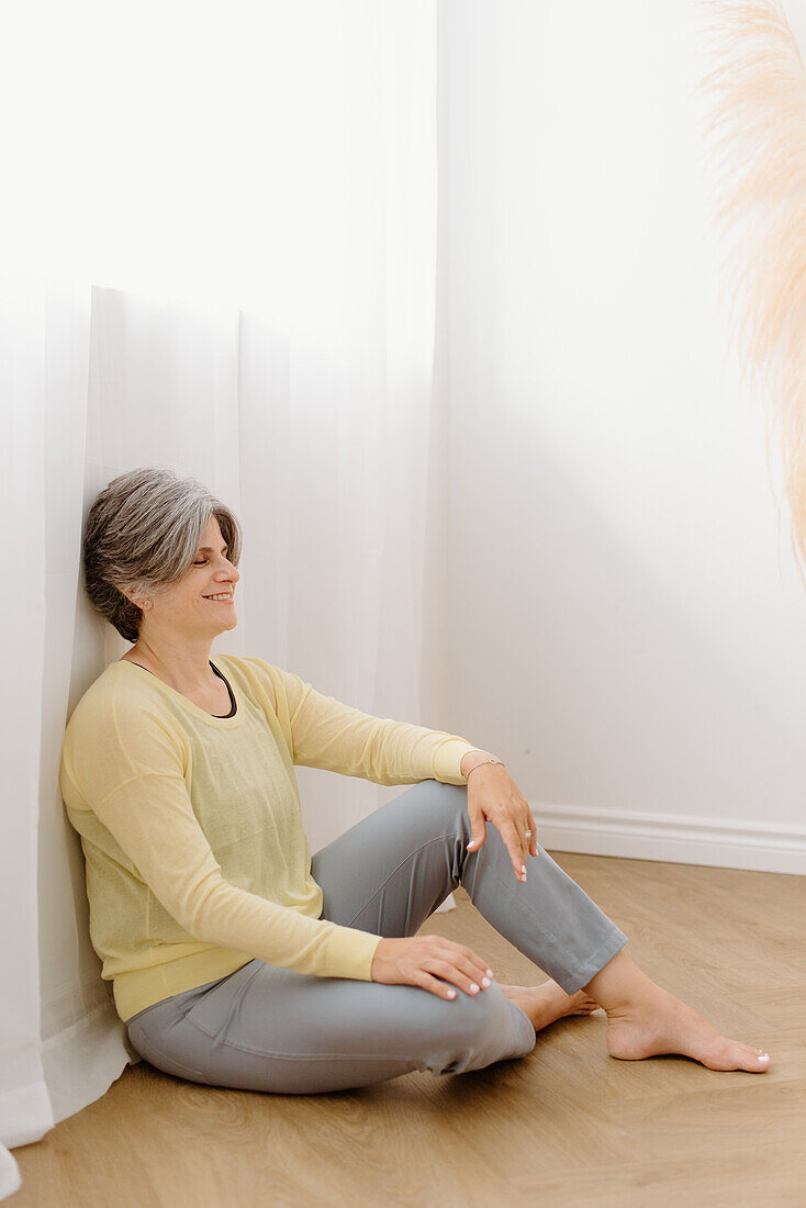 Smiling woman sitting on floor at home