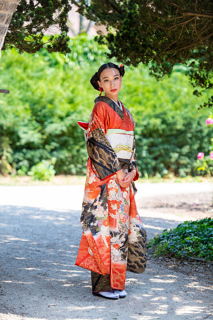 Portrait of woman wearing kimono standing in park