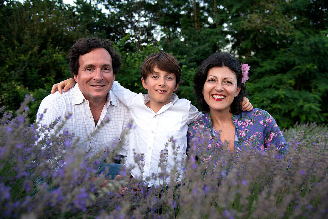 Porträt einer lächelnden Familie mit Sohn (8-9) in einem Lavendelfeld