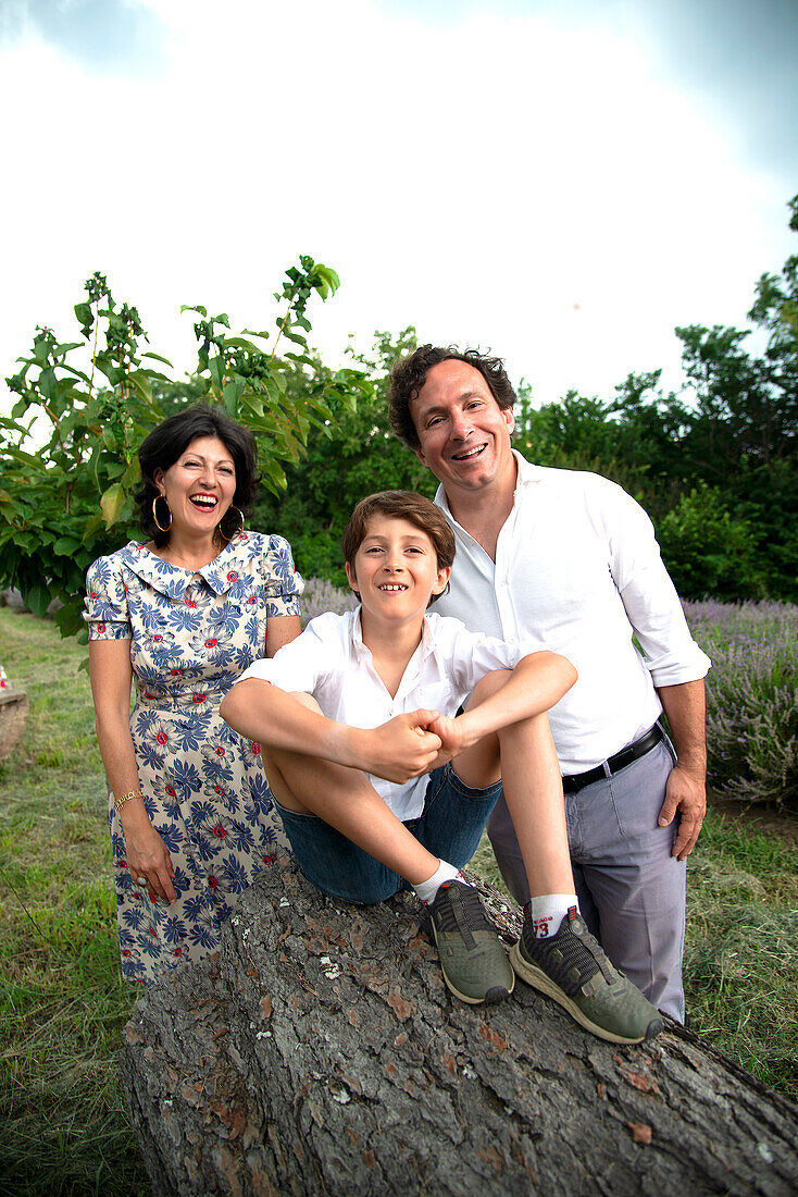Porträt einer lächelnden Familie mit Sohn (8-9) in einer Landschaft