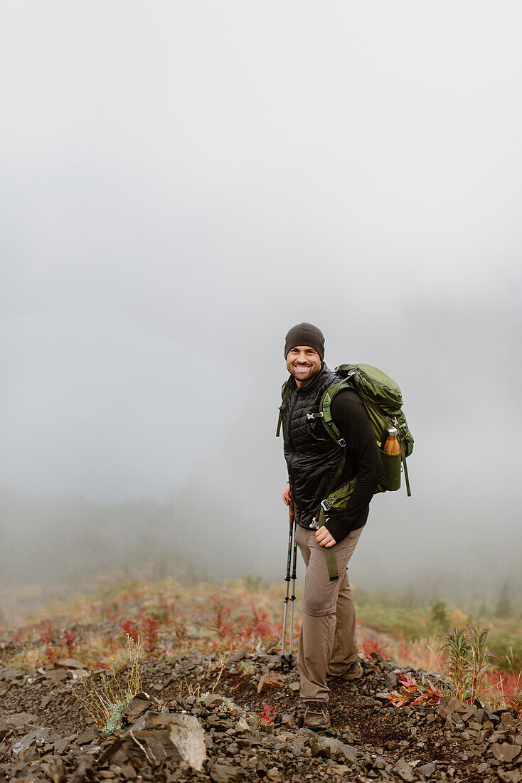 Canada, Yukon, Whitehorse, Portrait of smiling man hiking in foggy landscape