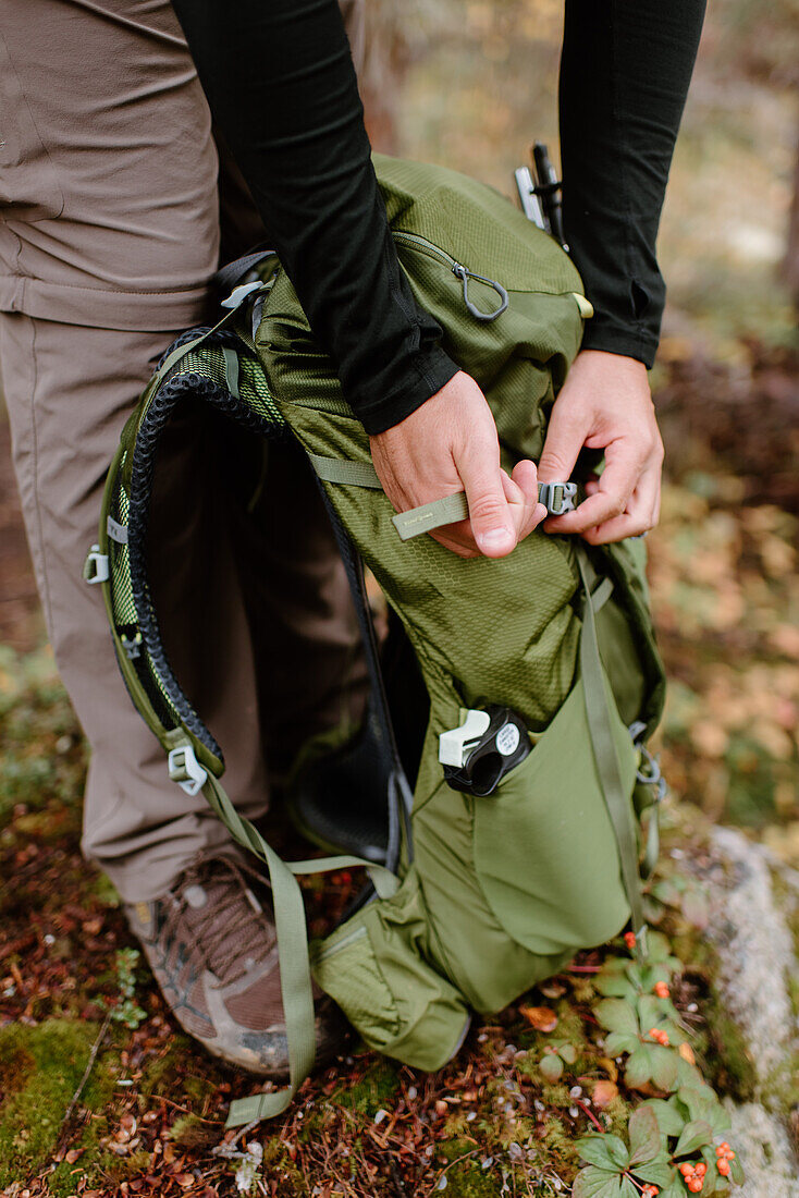 Canada, Yukon, Whitehorse, Hiker fastening backpack on footpath