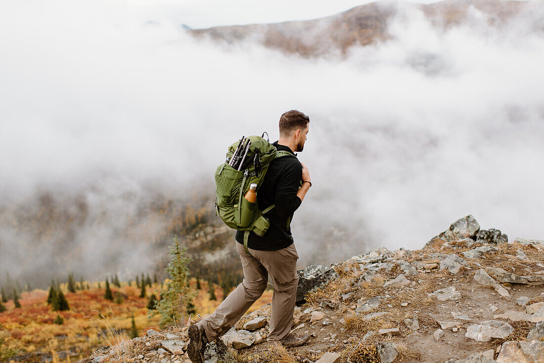 Kanada, Whitehorse, Mann mit Rucksack beim Wandern in felsiger Landschaft