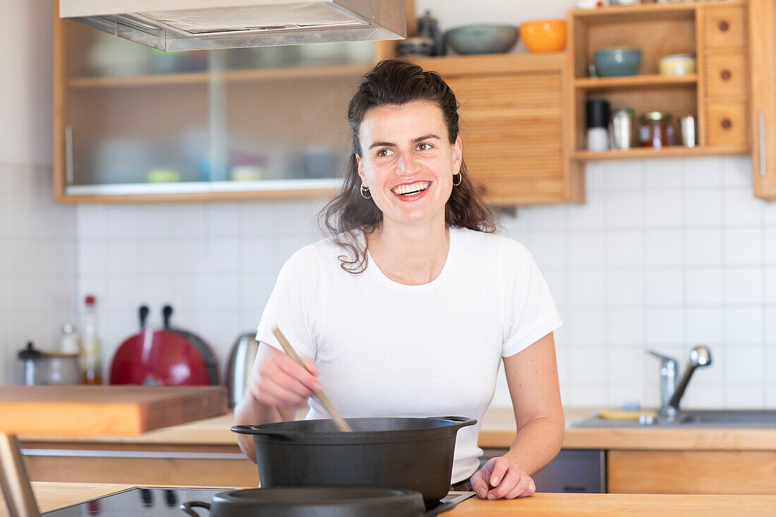 Lächelnde Frau beim Kochen