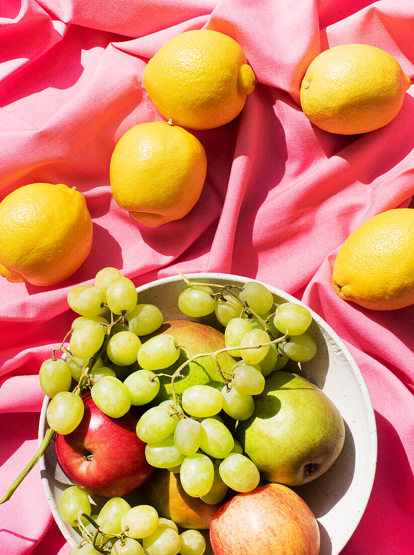 Verschiedene Früchte auf rosa Tischtuch