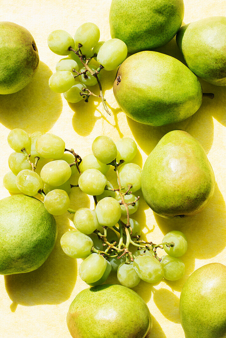 Overhead view of pears and grapes on yellow table cloth