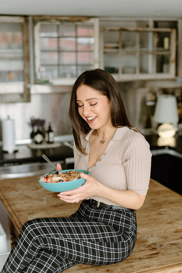 Smiling young woman holding granola bowl