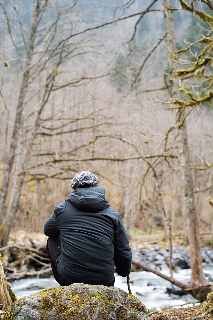 Türkei, Rückansicht eines Mannes, der auf einem Felsen am Bach im Wald sitzt