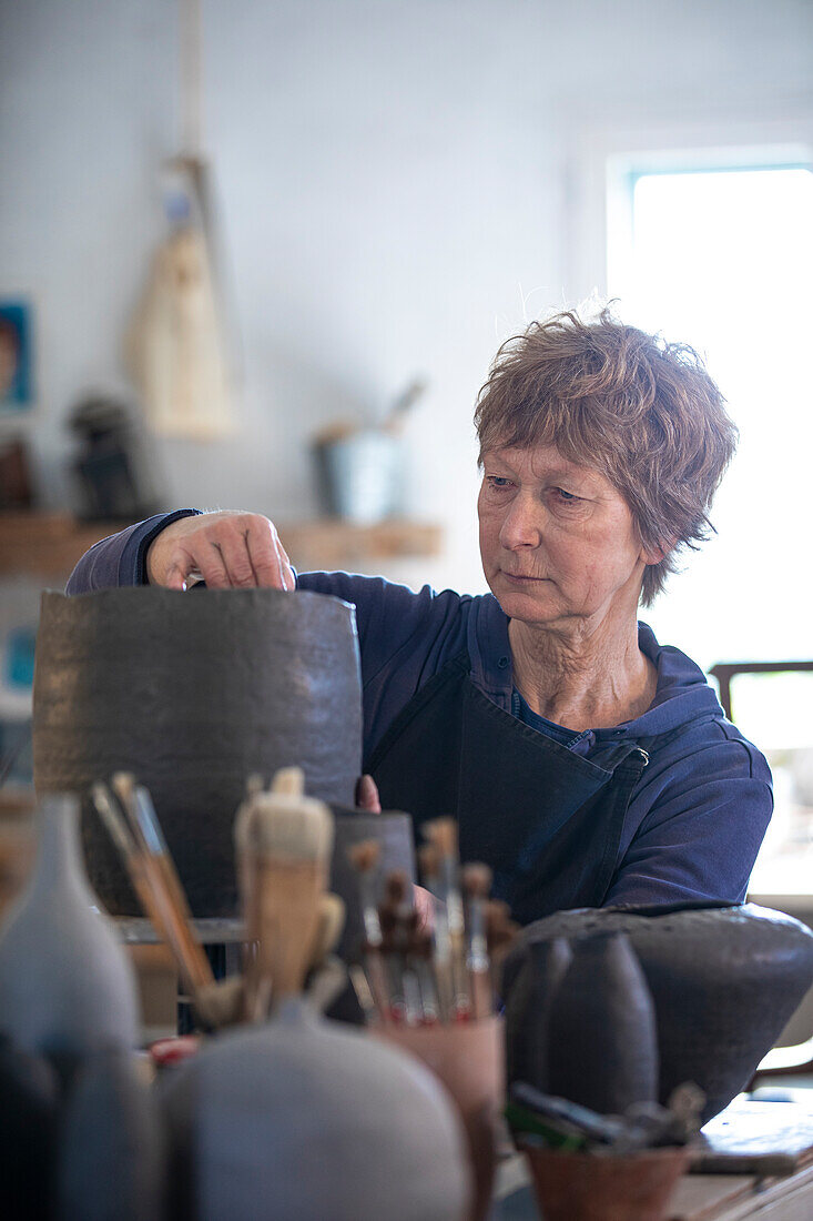 Spanien, Balearen, Frau macht Keramik in Werkstatt