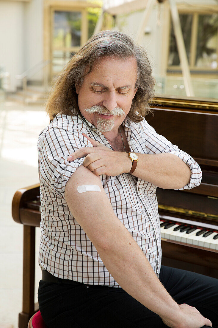 Österreich, Porträt eines Pianisten mit Klebeband am Arm