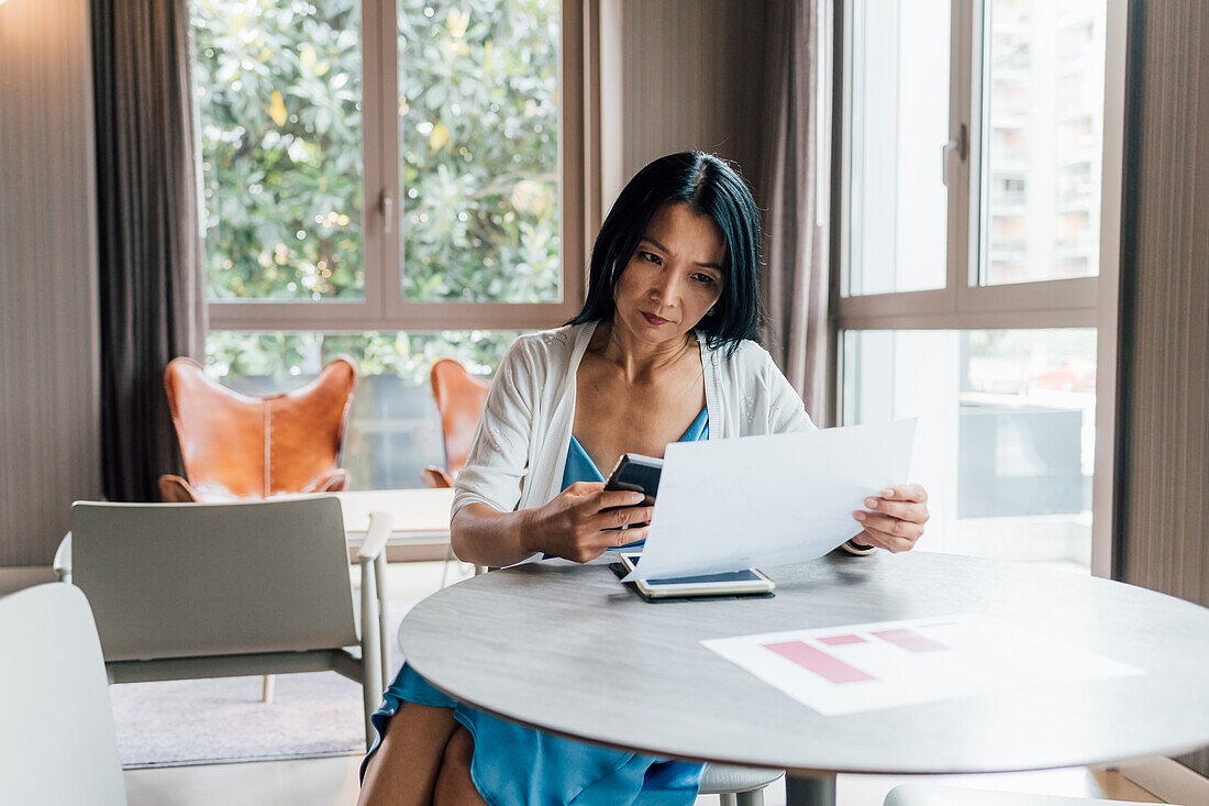 Italy, Businesswoman working at table in creative studio