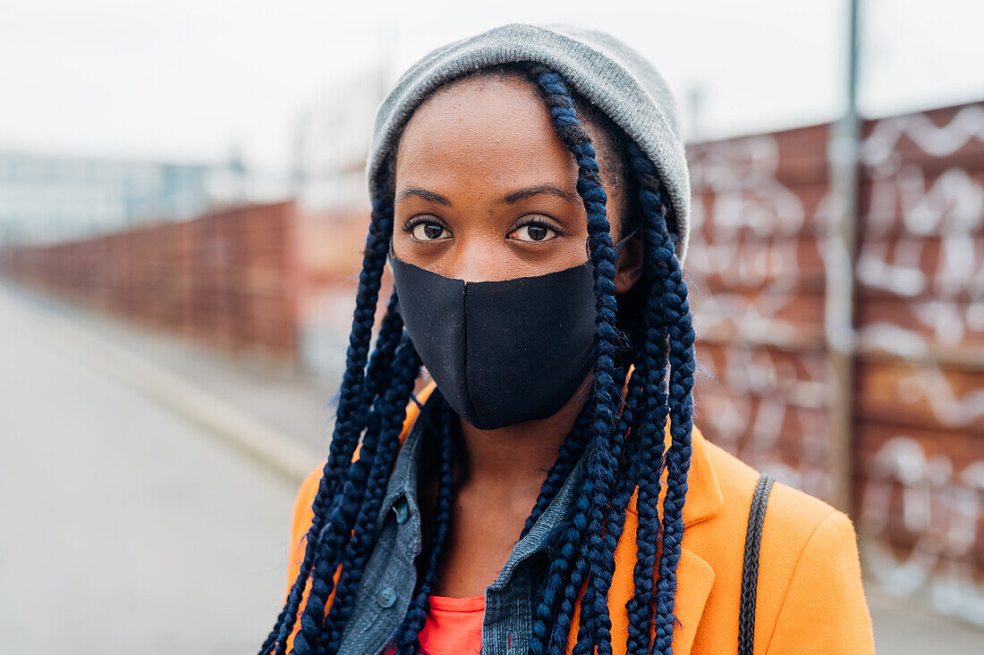 Italien, Mailand, Porträt einer Frau mit Gesichtsmaske auf der Straße
