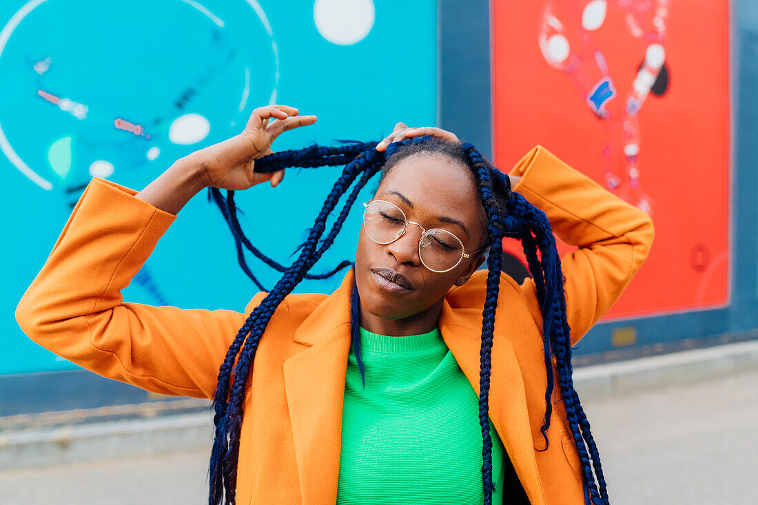 Italy, Milan, Young woman with braids outdoors