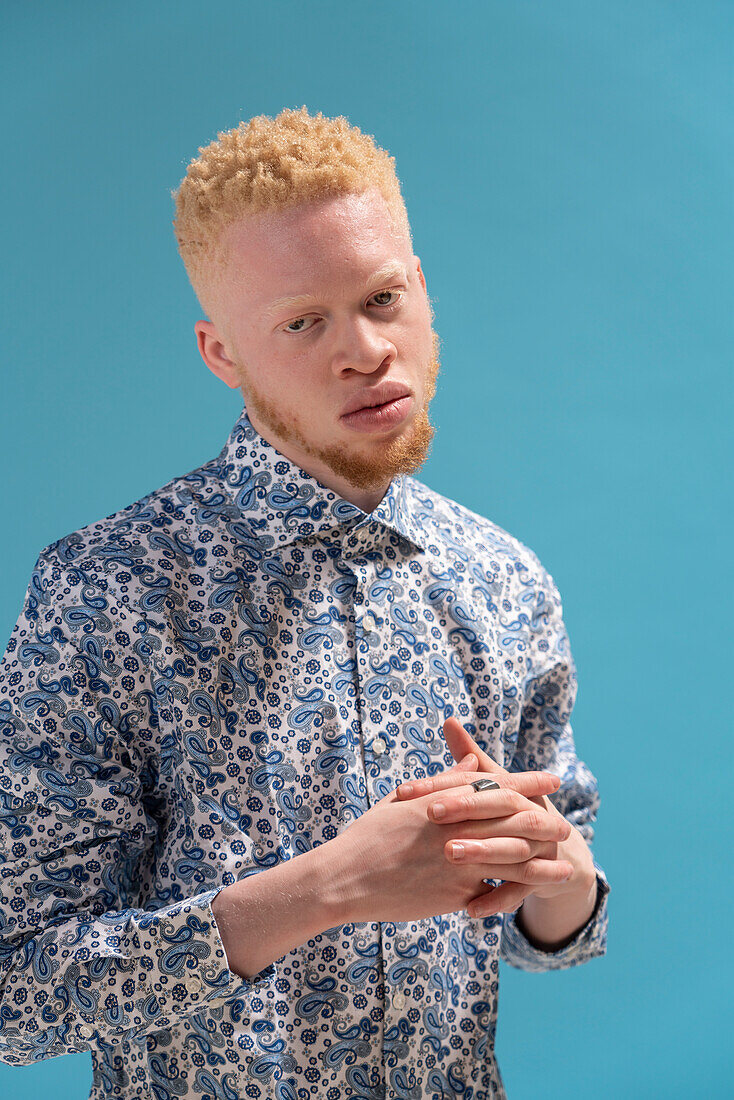 Studio portrait of albino man in blue patterned shirt