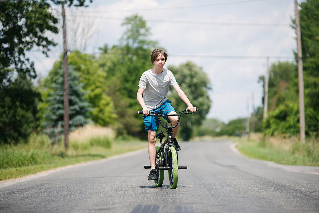 Canada, Ontario, Kingston, Boy (14-15) riding bicycle