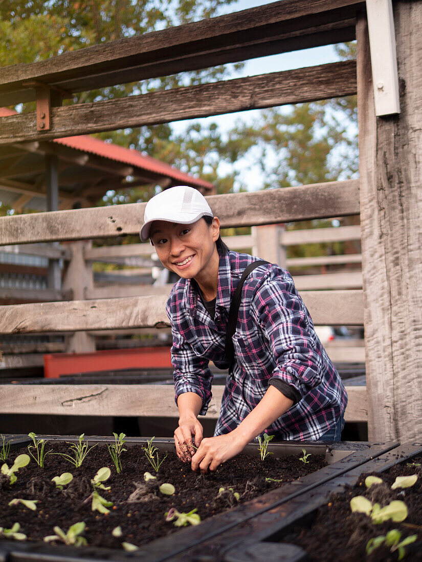 Australien, Melbourne, Porträt einer lächelnden Frau bei der Arbeit im Gemeinschaftsgarten