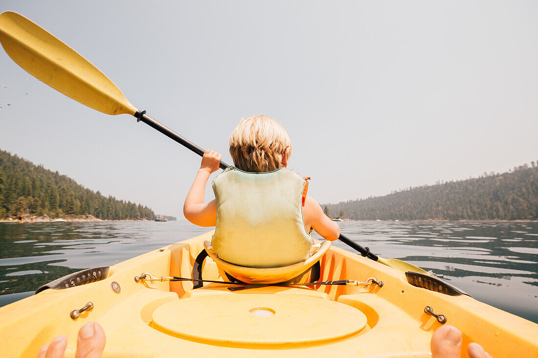 Boy (8-9) rowing in kayak