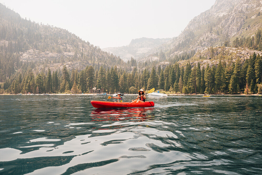 Woman with daughter (7-8) in kayak at lake