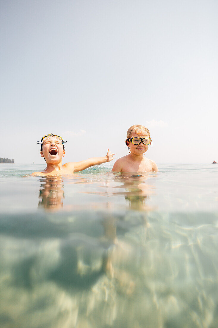 Junge (8-9) mit Schwimmbrille im See