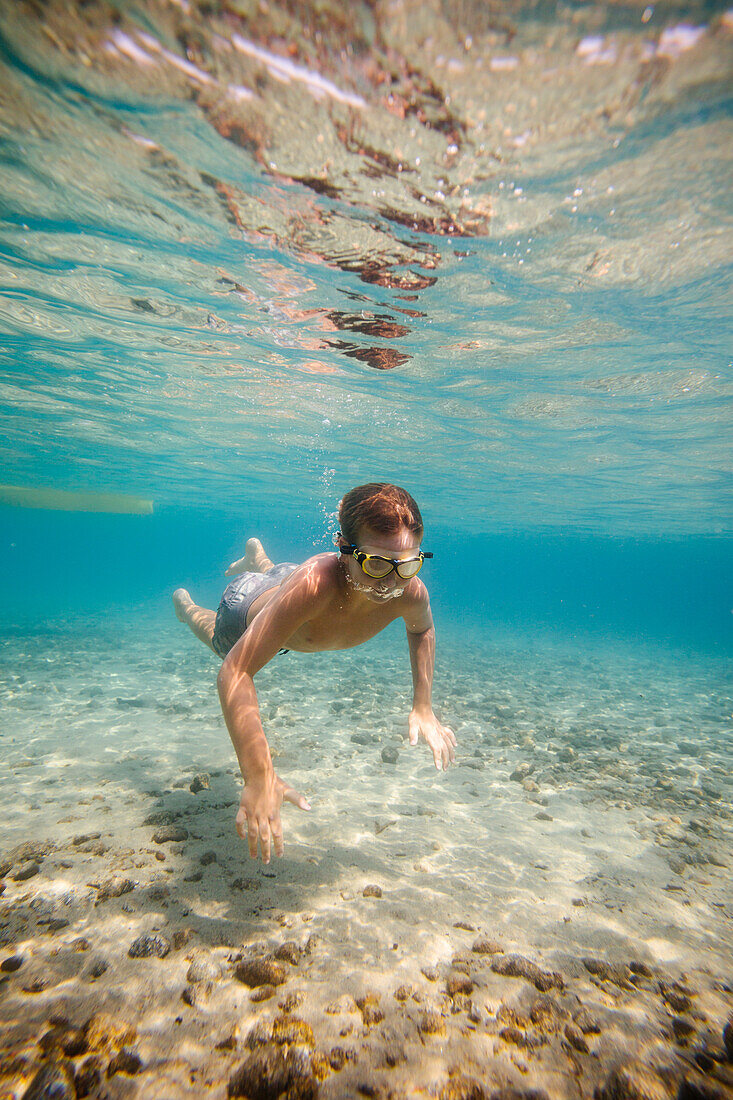 Junge (8-9) schwimmt unter Wasser