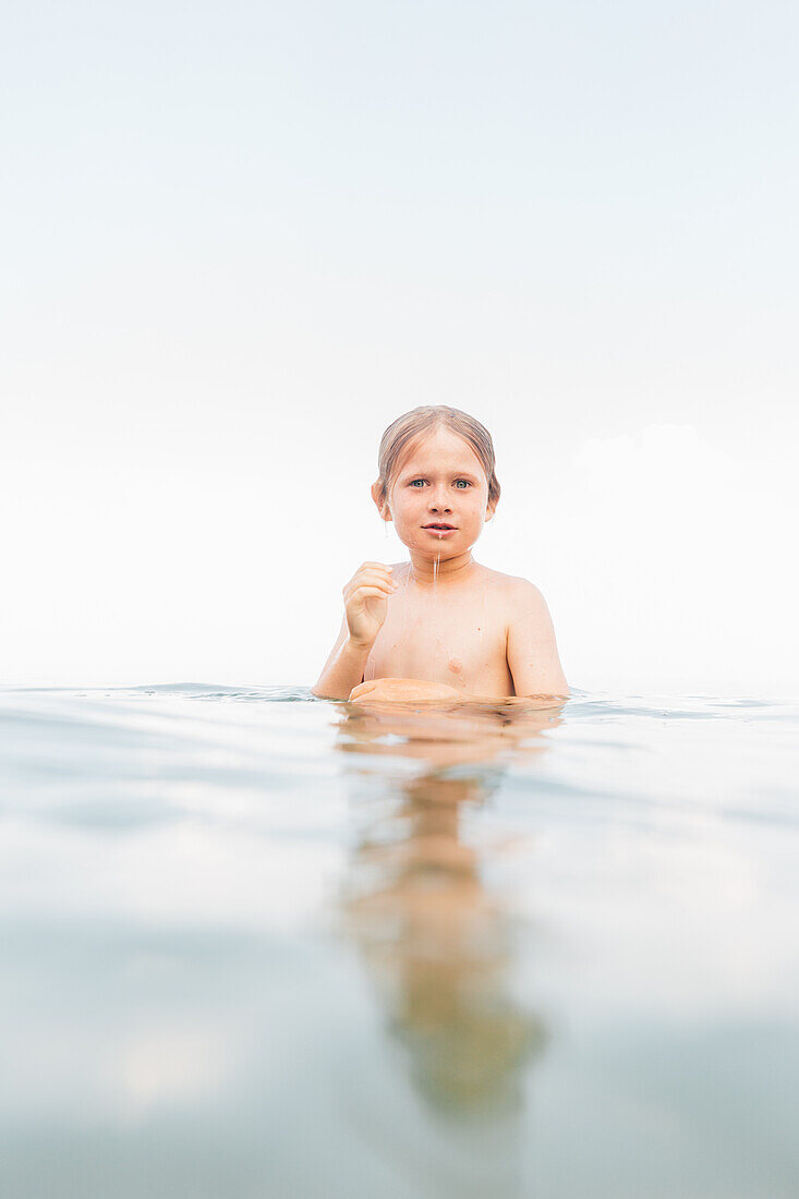 Boy (8-9) standing in lake