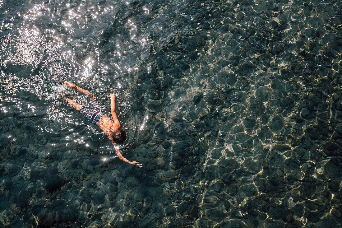 Boy (12-13) swimming in lake