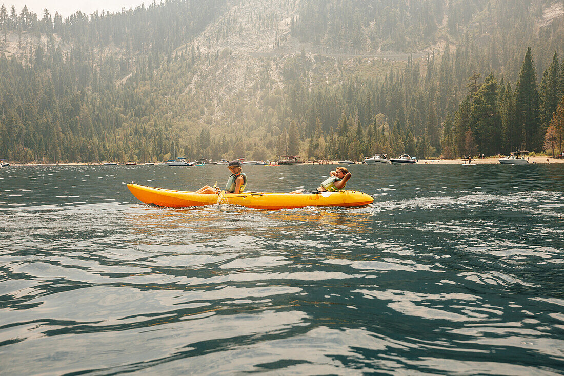 Boys (12-13) in kayak at lake