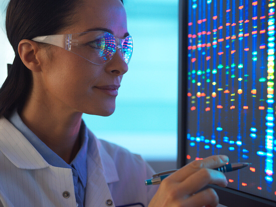 Lächelnde Wissenschaftlerin mit DNA-Sequenzierung in der Brille