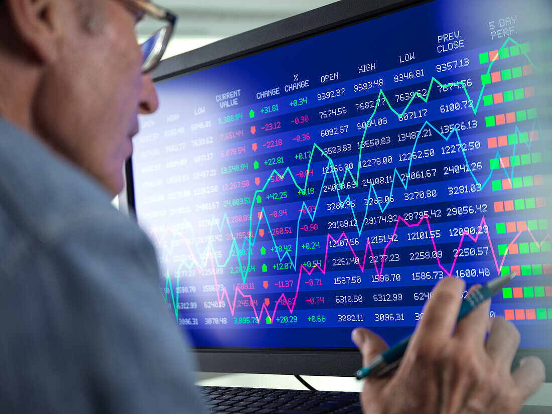 Stock trader viewing performance of shares on screen
