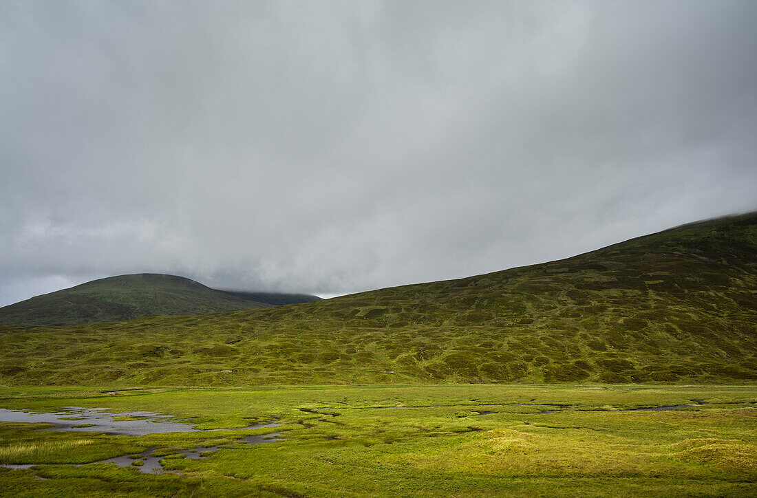 UK, Scotland, Storm clouds above green hills