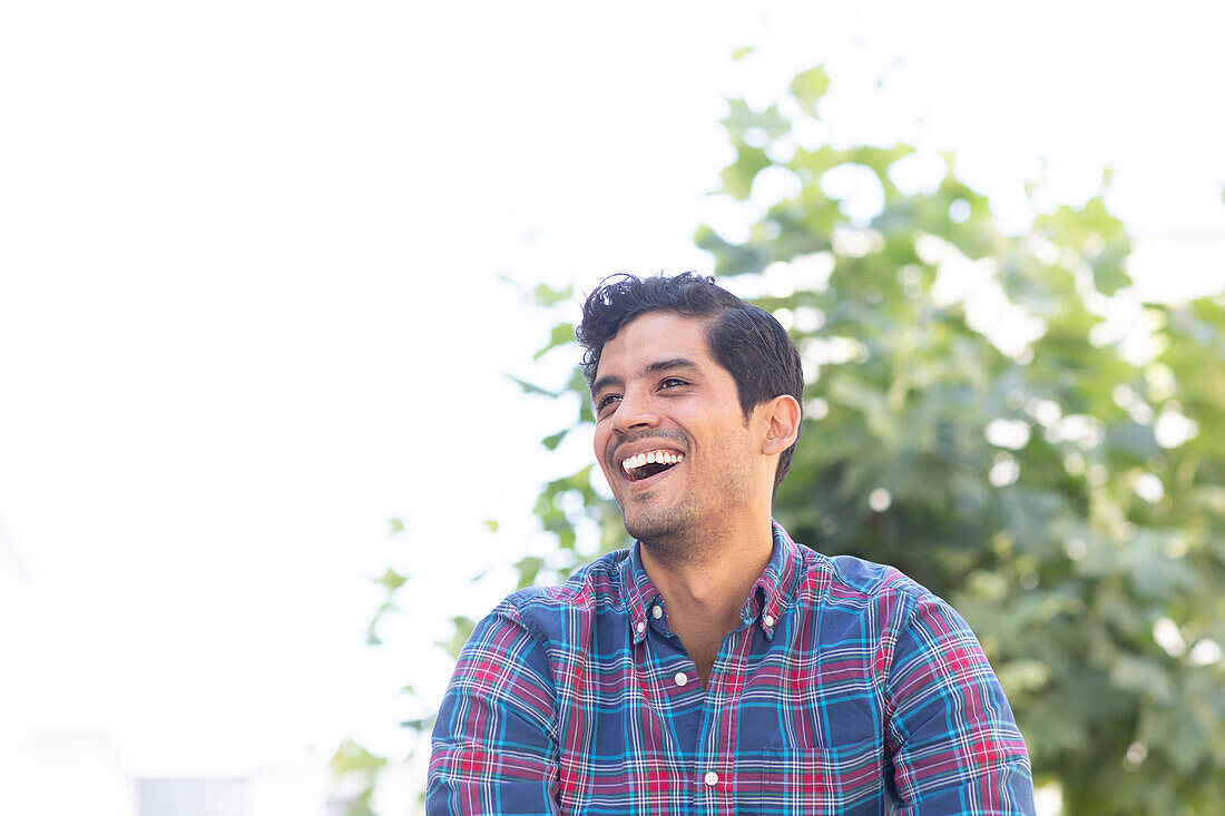 Young man laughing outdoors