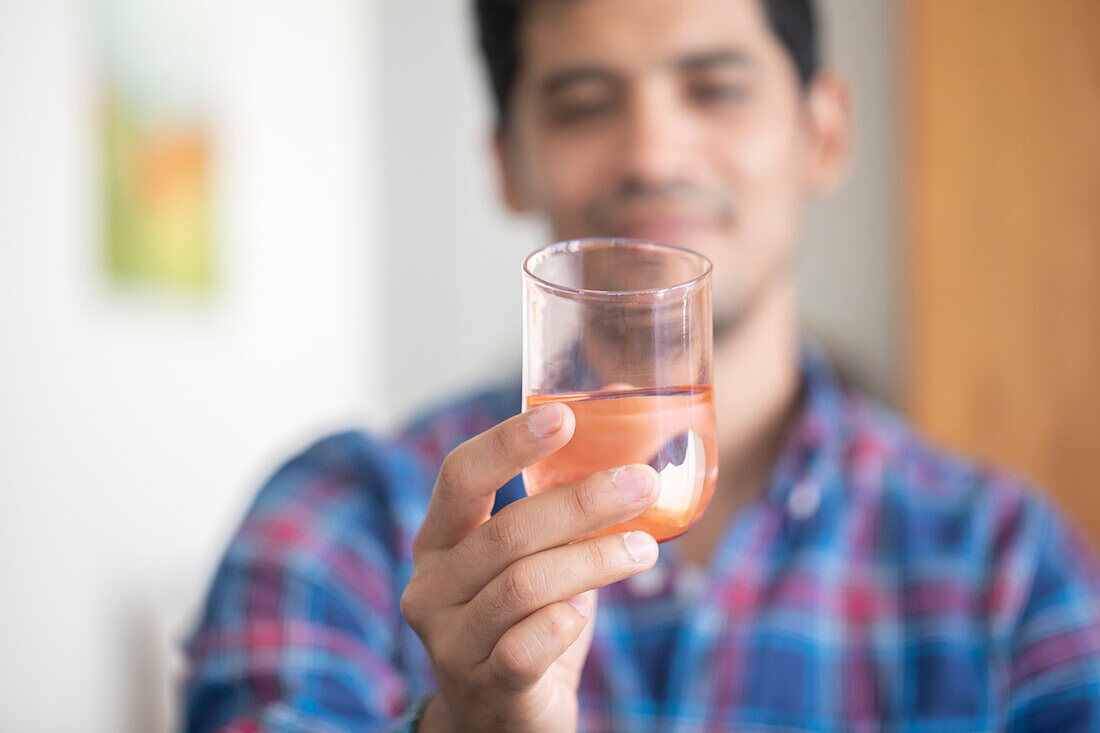 Mann hält ein Glas Wasser