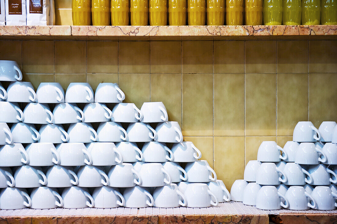 Weiße Tassen auf dem Kopf stehend auf einem Tresen in einem Restaurant gelagert; Barcelona, Spanien