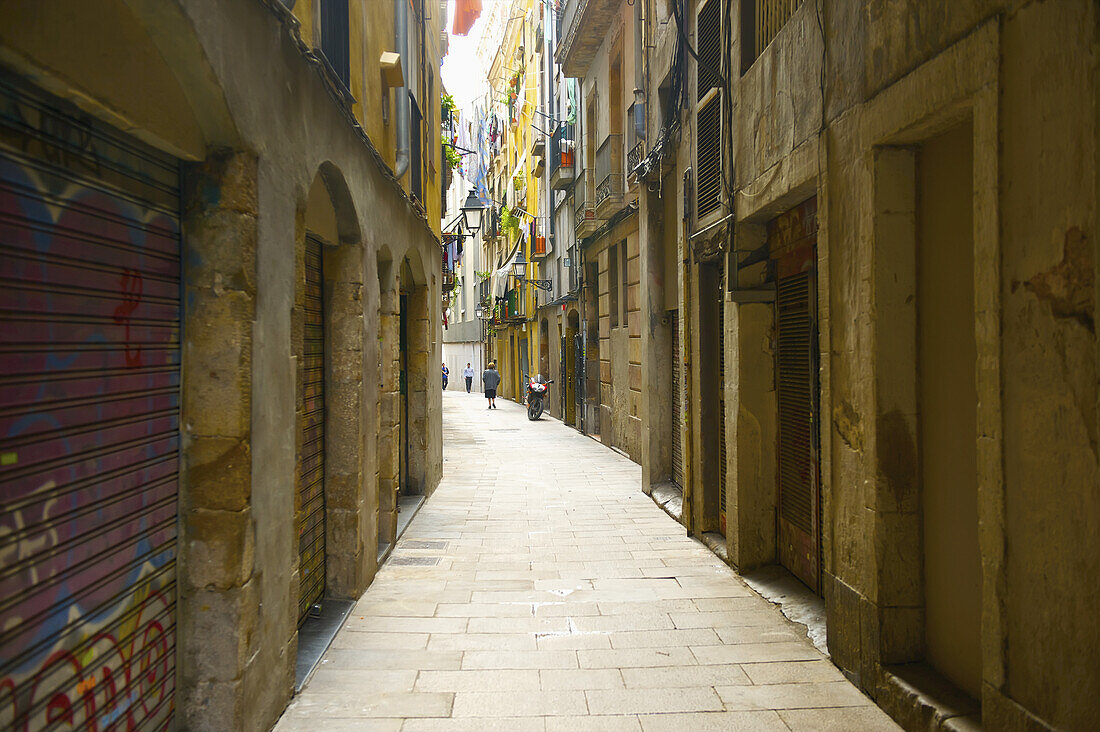 A Narrow Street In Between Buildings; Barcelona, Spain