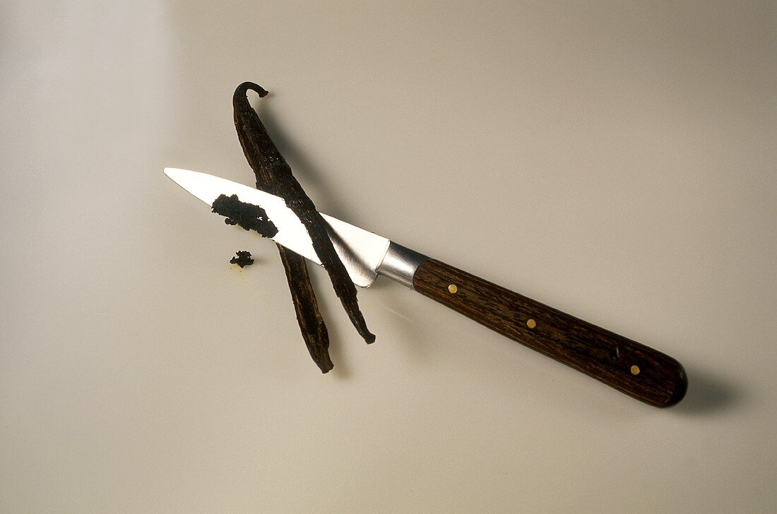 Halved vanilla stick & vanilla pulp on knife