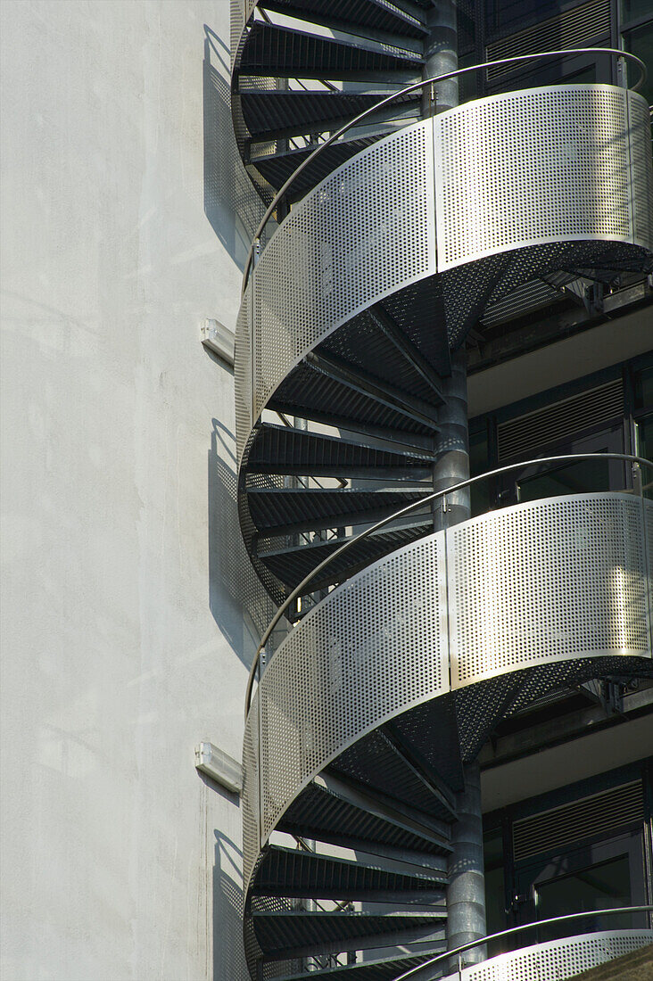 Eine Wendeltreppe mit einer silbernen Metallwand und einem Geländer an der Außenseite eines Gebäudes; Hamburg, Deutschland