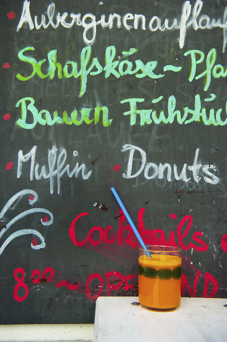 Eine Tafel mit Werbung für Essen in einem Restaurant und ein Getränk auf einem Tisch; Hamburg, Deutschland