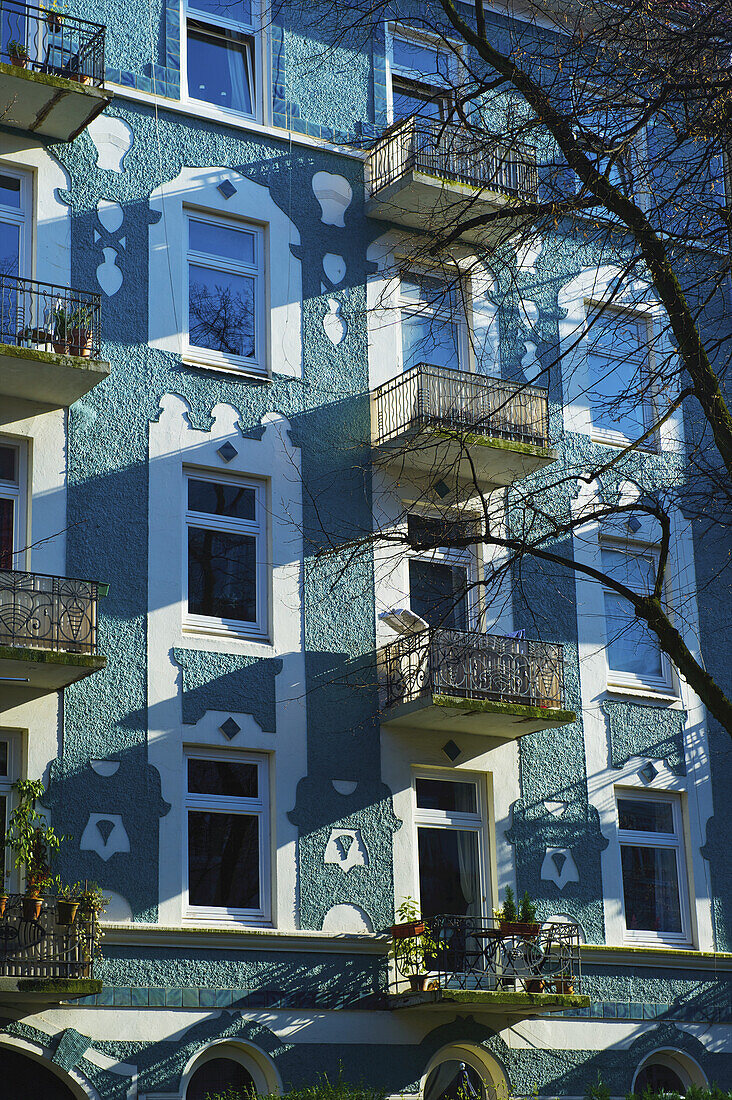 Fassade eines Wohnhauses mit verschnörkelten weißen Fenstern und kleinen Balkonen; Hamburg, Deutschland