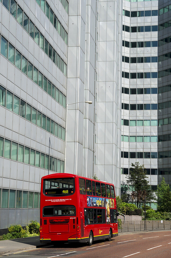 Ein roter Doppeldeckerbus auf der Straße unterhalb eines Bürogebäudes, Croydon; London, England