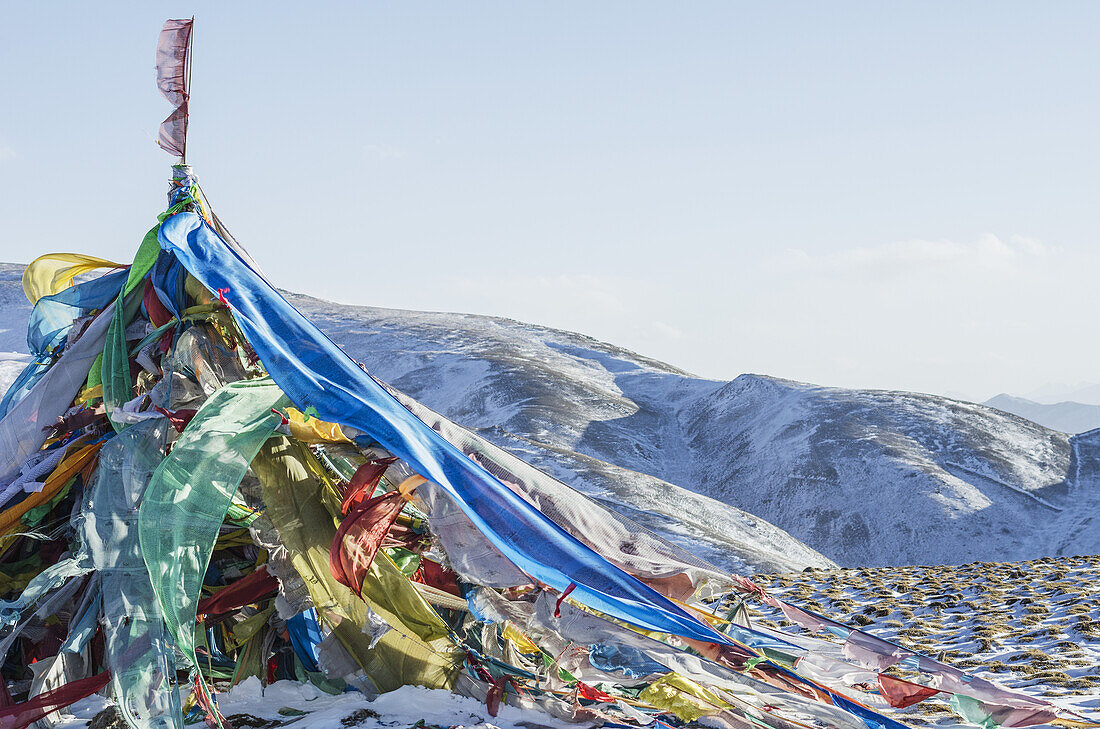 Schneelandschaft mit Gebetsfahnen auf einem hochgelegenen Bergpass; Tibet