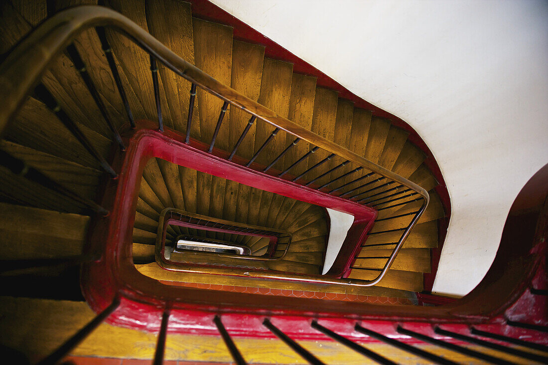 Hoher Blickwinkel auf eine hölzerne Treppe, Handlauf und Geländer in einem Gebäude, Marais-Viertel; Paris, Frankreich