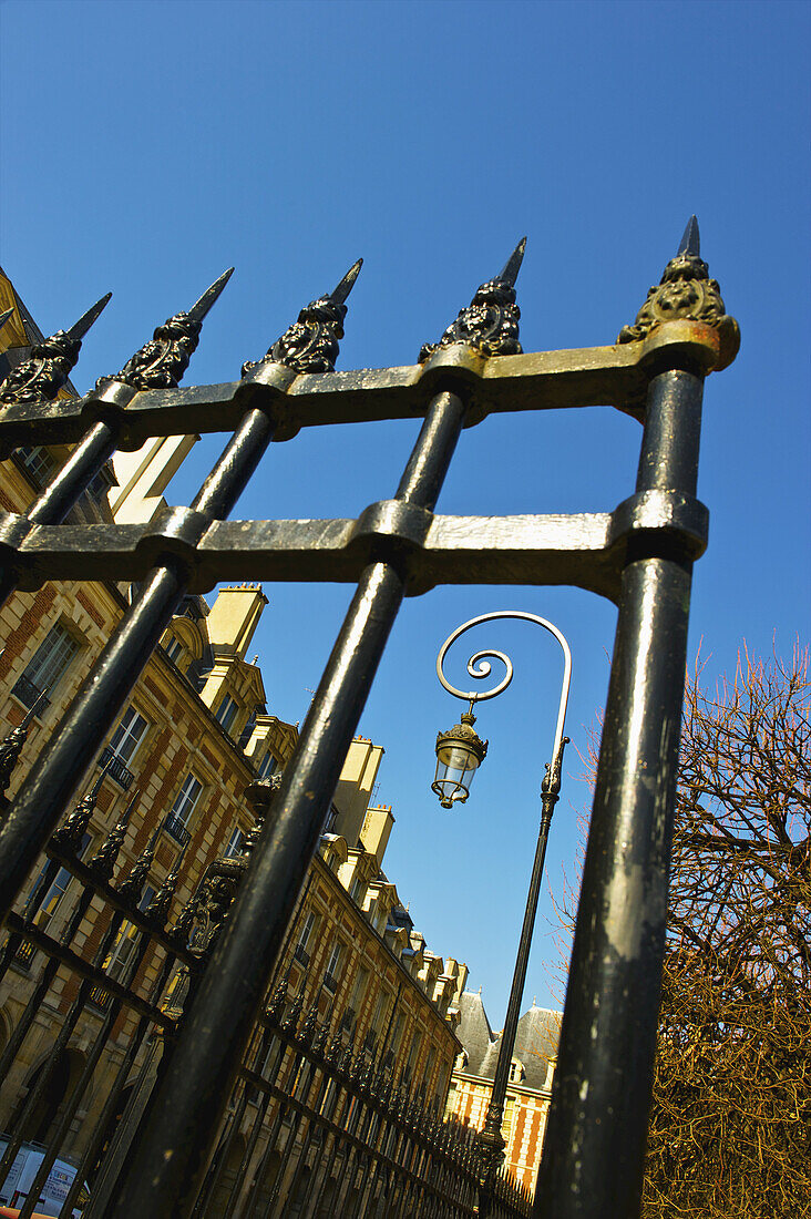 An Ornate Metal Railing By A Building And Blue Sky, Marais District; Paris, France