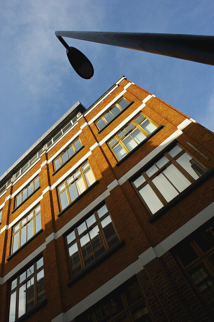 Low Angle View Of A Brown Brick Building, Street Light And Blue Sky, Shoreditch; London, England