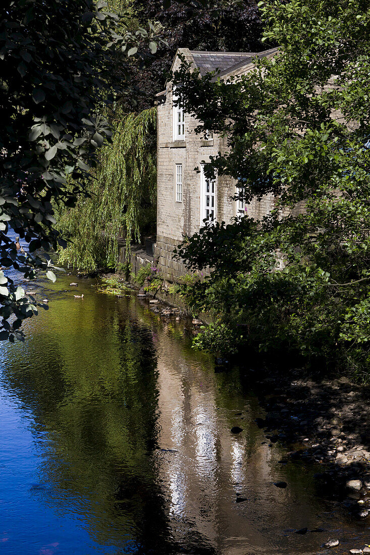 Tranquil Canal With Reflection Of A Building And Trees; Yorkshire, England