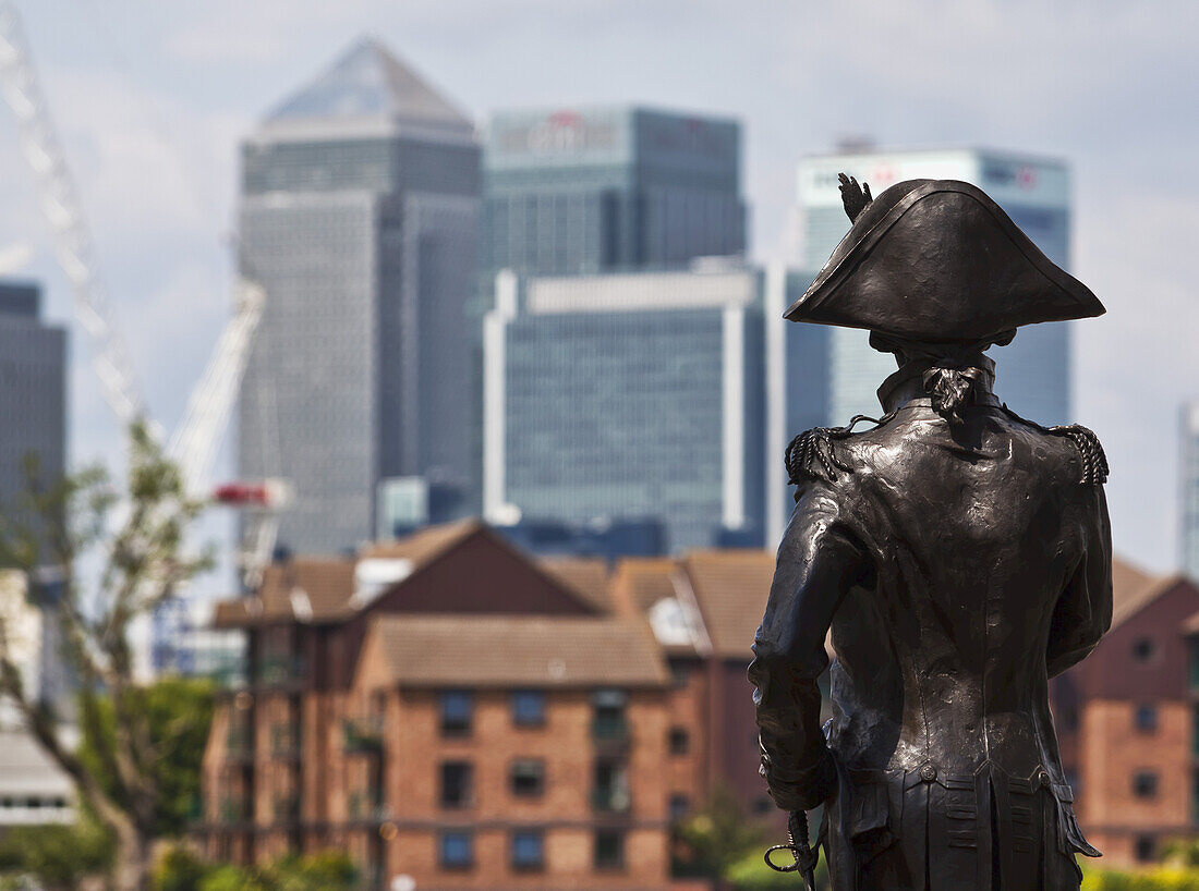 Skulptur von Admiral Lord Nelson in Greenwich mit den Gebäuden von Canary Wharf im Hintergrund; London, England