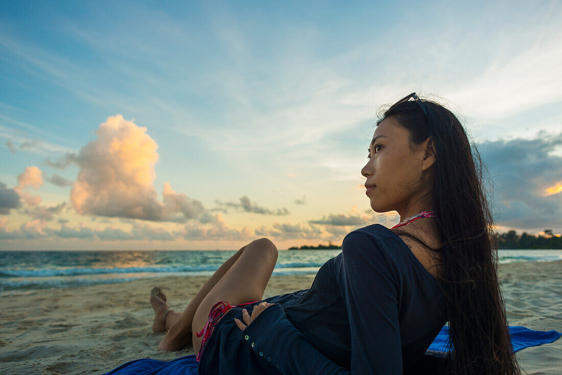 A Young Woman Lays Posing On Sokha Beach At Sunset; Sihanoukville, Cambodia