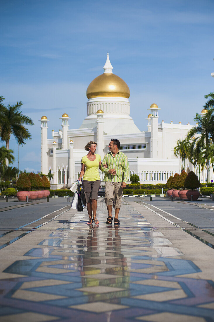 Paar beim Einkaufen mit Sultan Omar Ali Saifuddien Moschee im Hintergrund; Bandar Seri Begawan, Brunei