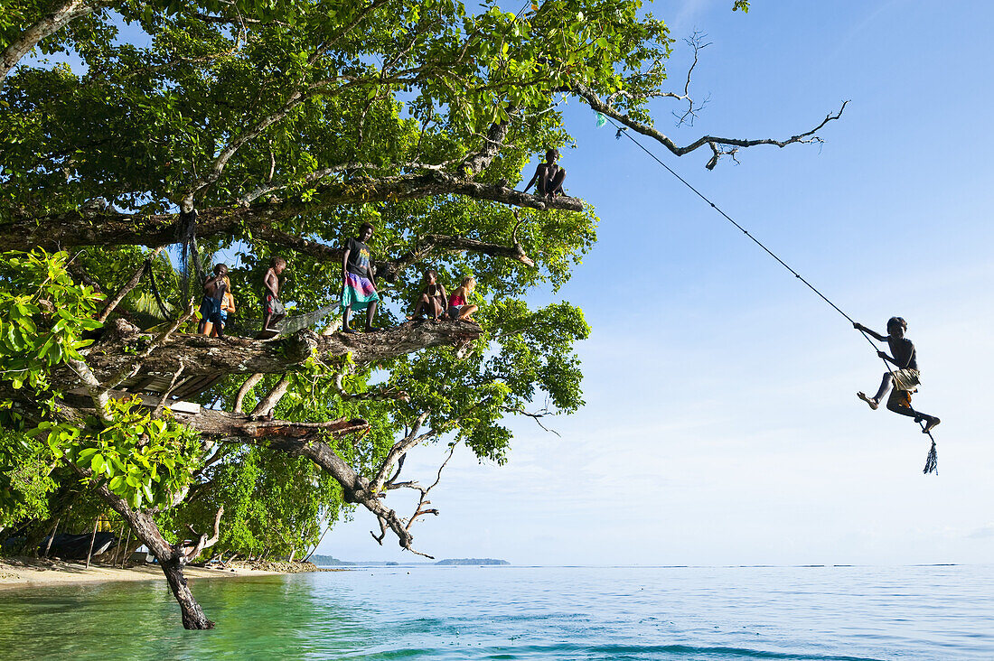 Solomon Island Boy Swinging From A Rope; Gizo, Western Province, Solomon Islands